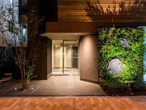スーパーホテル Premier秋葉原 — 東京・千代田区 · 緑化壁を配した都市型ビジネスホテルのエントランス