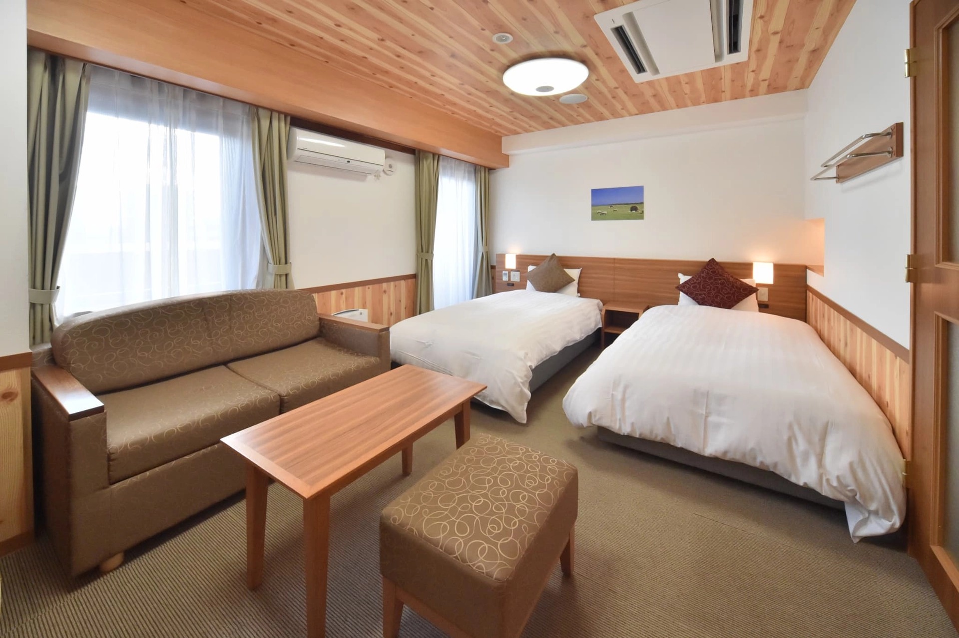 ドーミーインPREMIUM札幌 — 札幌市中央区南2条西6丁目 · ソファとローテーブルを置いたツイン客室