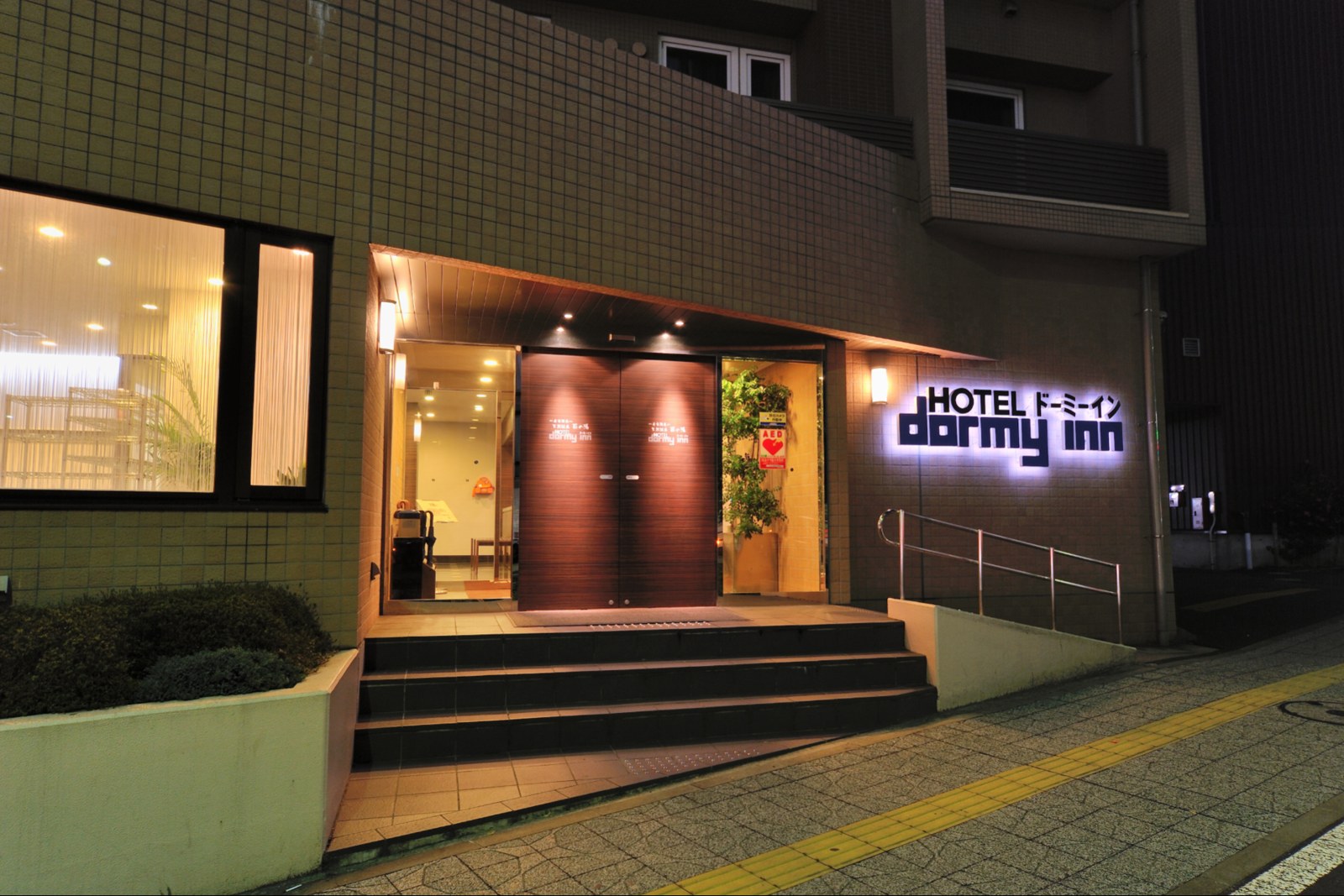 天然温泉 萩の湯 ドーミーイン仙台駅前 — 仙台市青葉区本町 · 仙台駅西口徒歩約4分、夜間のエントランス外観