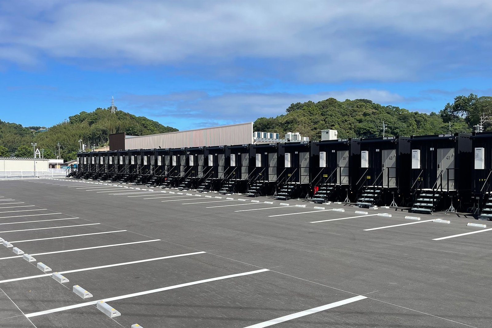 HOTEL R9 The Yard 上天草 — 熊本県上天草市大矢野町 · 55台の無料駐車場に面したコンテナ客室の列