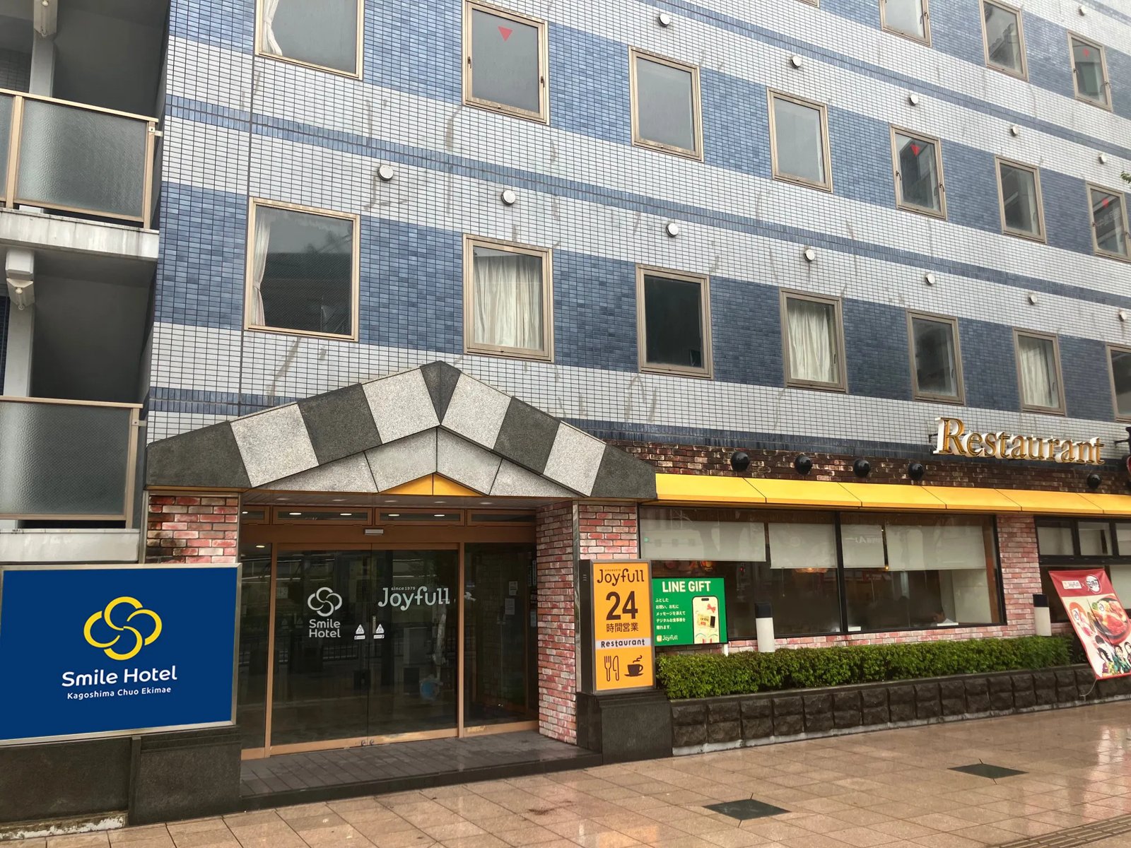 スマイルホテル鹿児島中央駅前 — 鹿児島市西田 · ホテル入口と1階の24時間営業レストラン「ジョイフル」